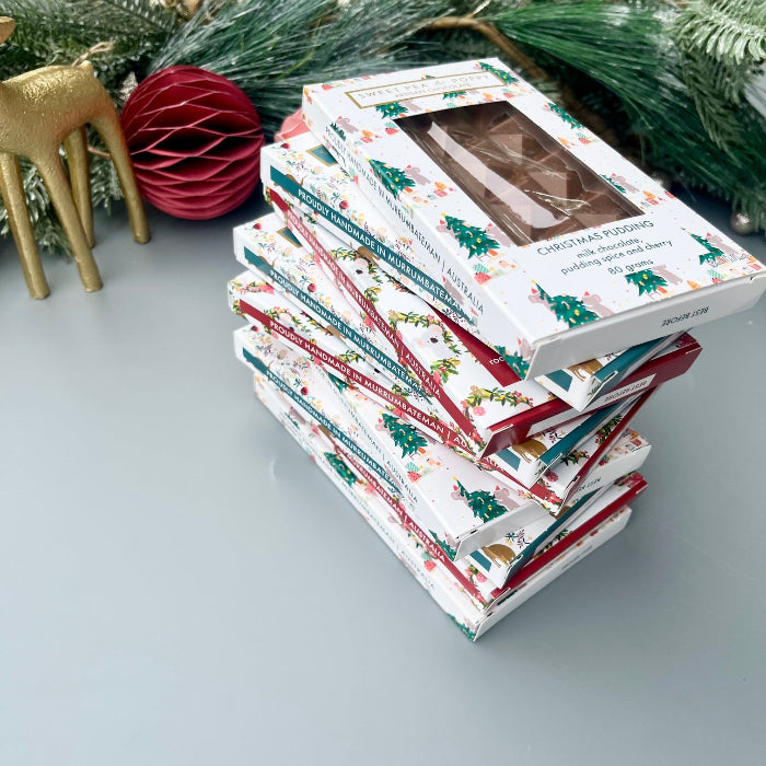 Stack of Christmas-themed chocolate bars with decorative elements on a light surface.