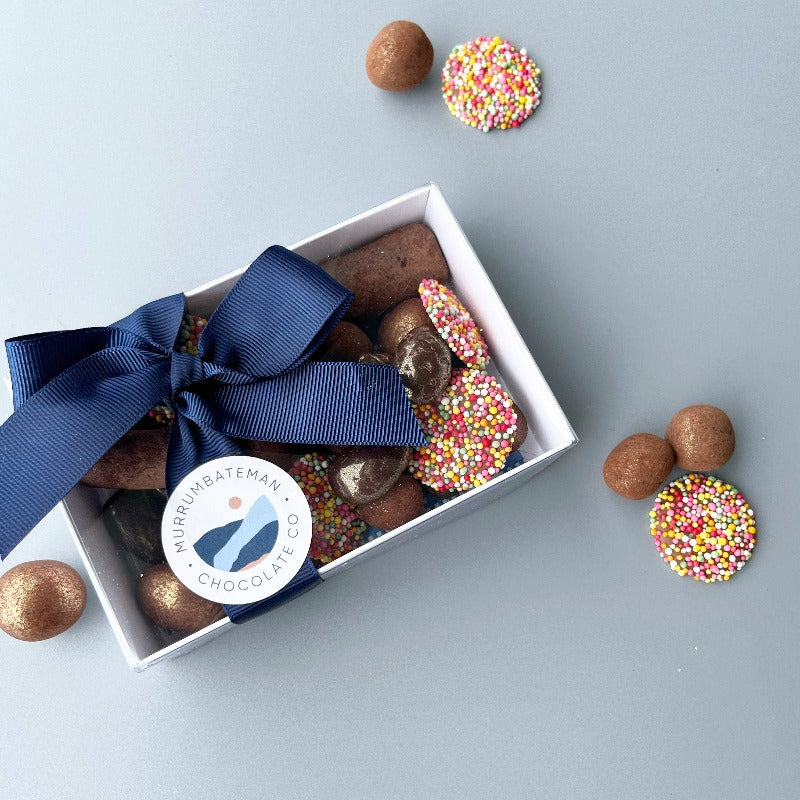 A gift box of mixed chocolates with a blue ribbon