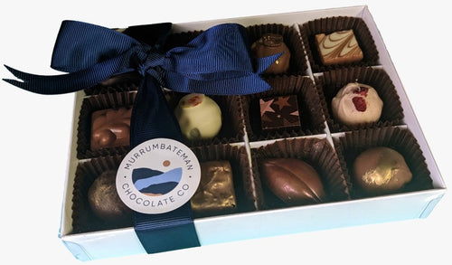 A gift box of handmade chocolate truffles with a blue ribbon