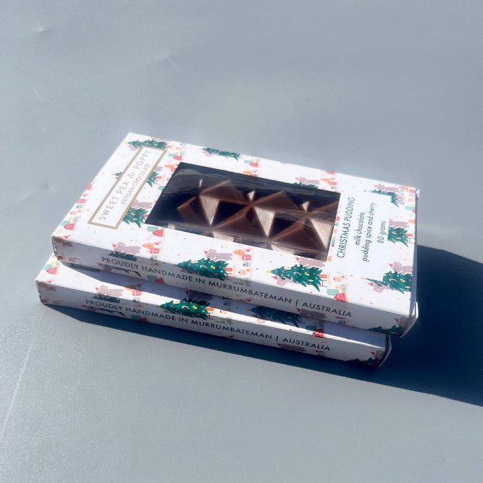 Two boxes of handmade chocolate Christmas pudding bars with Christmas designs